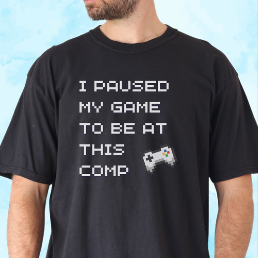 Adult t-shirt with I Paused My Game to Be at This Comp text in 8-bit font and video game controller graphic