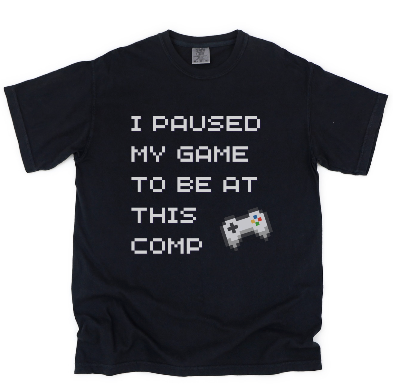 Black t-shirt with text 'I paused my game to be at this comp' and a pixelated game controller on a black background